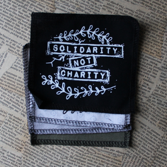 Solidarity not charity - pieni kangasmerkki